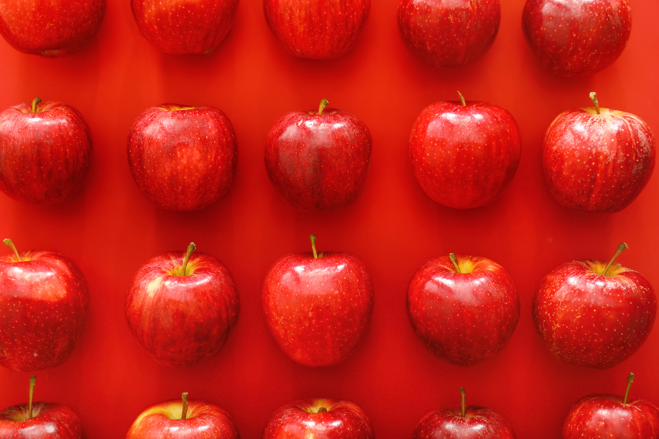 Ripe Apples on Red Background